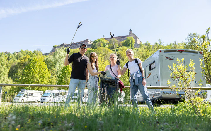 Team der dc AG sammelt Müll auf einer Wiese unterhalb der Plassenburg Kulmbach.