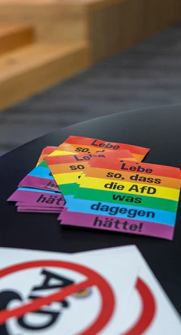 Regenbogenfarbene Sticker mit der Aufschrift 'Lebe so, dass die AfD was dagegen hätte.'