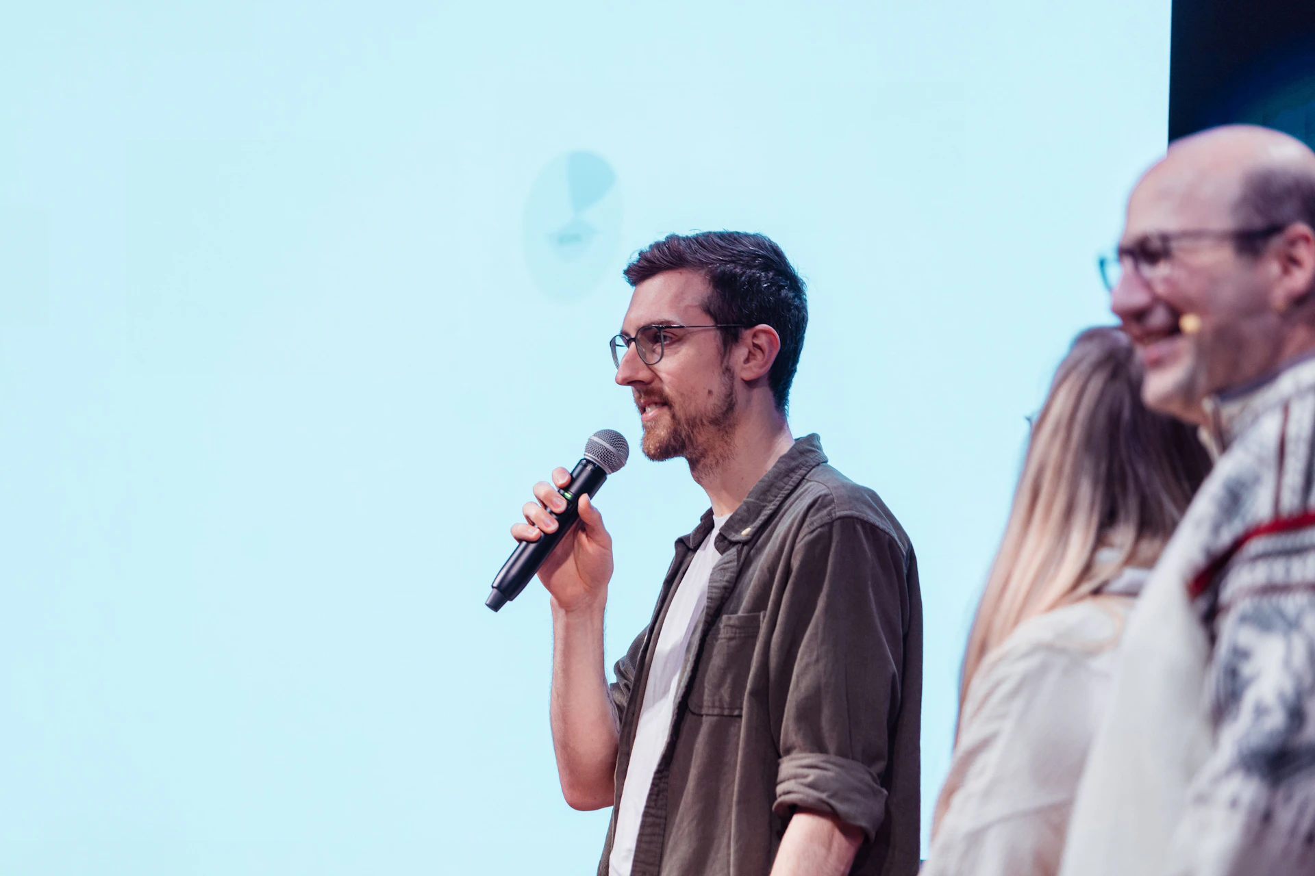 Robin von insightsoftware spricht mit einem Mikrofon auf einer Bühne während eines Events.