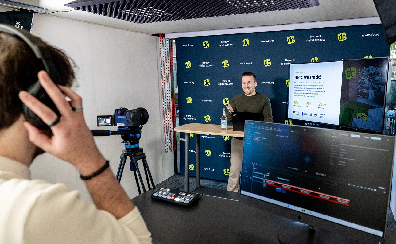 Ein Referent steht vor einer Kamera in einem Videostudio für eine digitale Schulung bei dc.