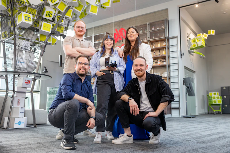 Fünf lächelnde Teammitglieder der dc AG präsentieren stolz eine Auszeichnung des German Web Award.