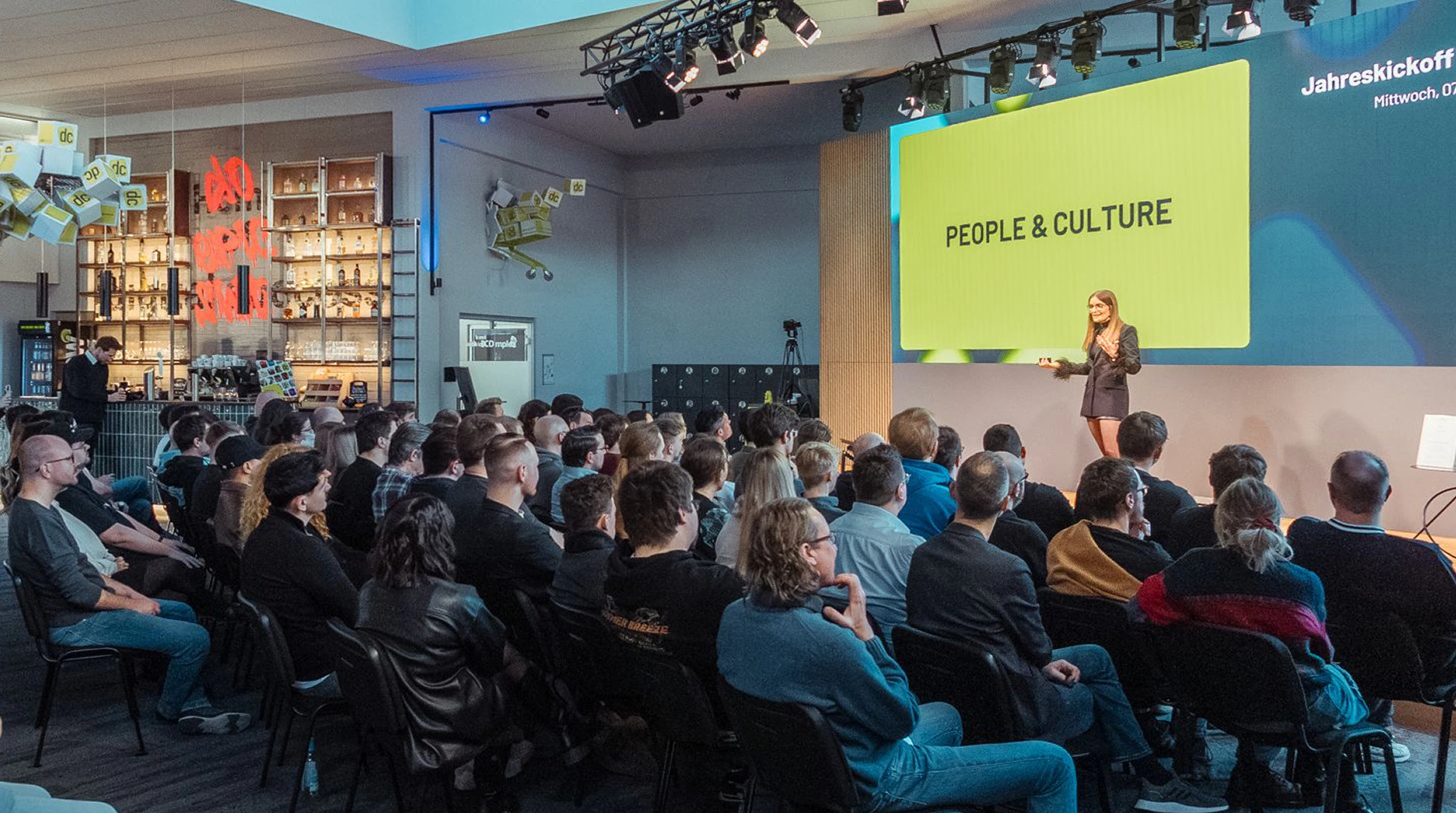 Referantin präsentiert die Folie People and Culture beim Jahreskickoff vor Publikum.