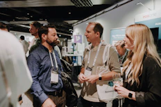 Besucher im Gespräch auf der Directions EMEA 2024 am Messestand von dc AG.